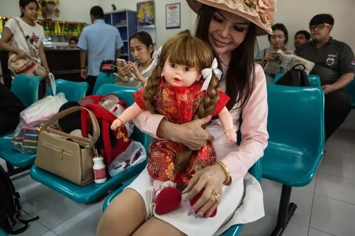 带着古曼童玩偶出行的泰国妇女