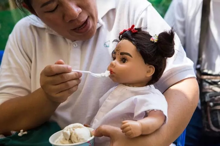 一位叫Pita的泰国妇女正在给自己的古曼童玩偶喂冰淇淋